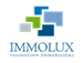 Logo de l'agence immobilière IMMOLUX avec des formes géométriques bleues et vertes sur fond transparent.